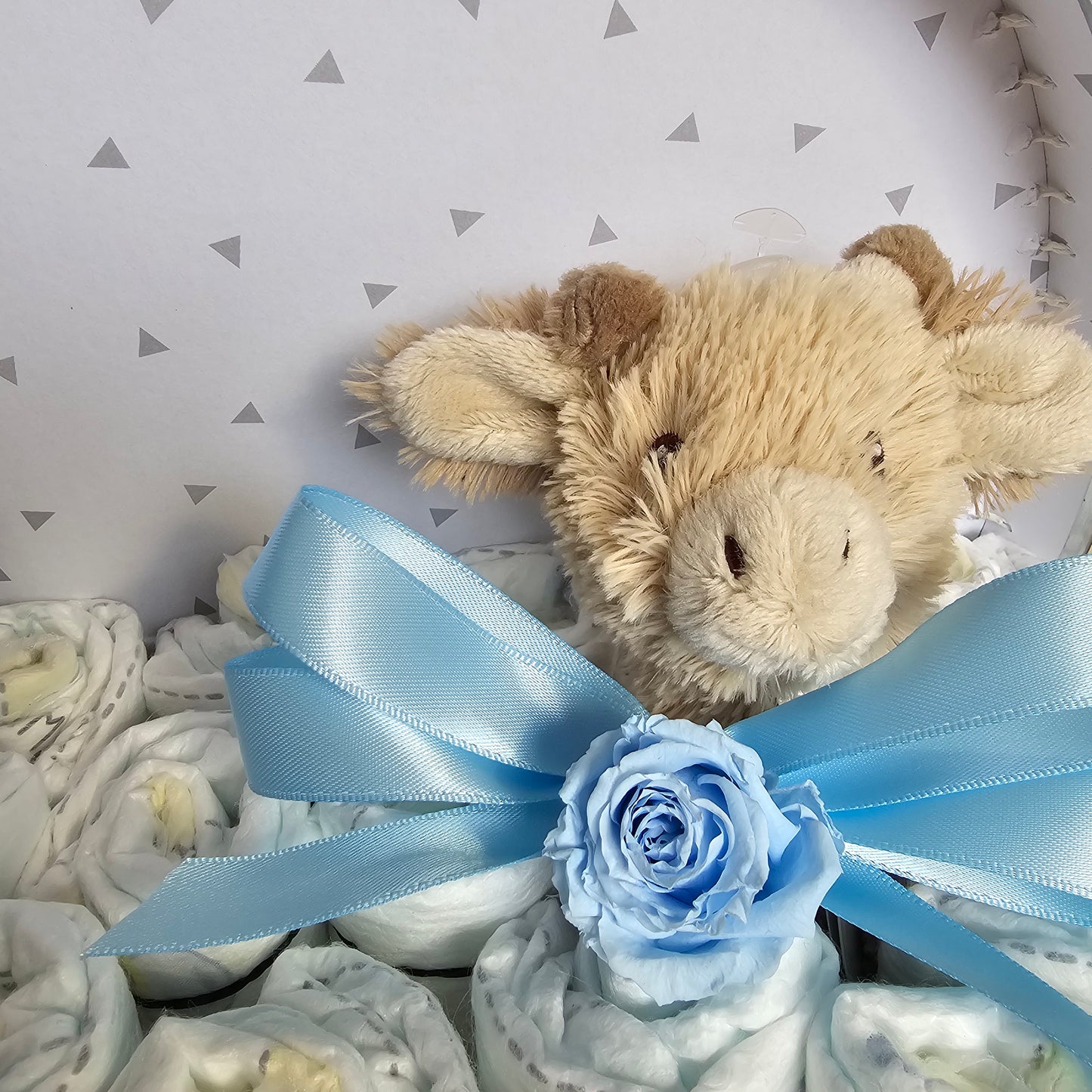 Luiertaart in een gepersonaliseerd blauw koffertje met knuffeltje giraf gus en echte longlife rozen