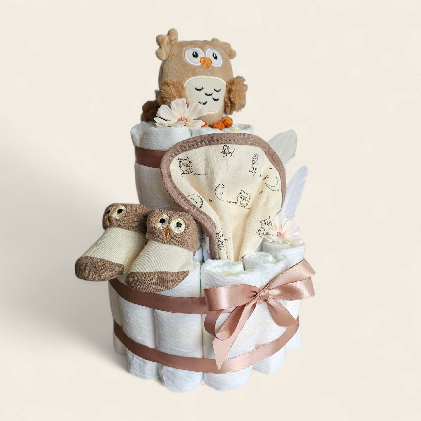 Luiertaart uil 2 laags bruin met pampers rammelaar slabber en sokjes vanaf de zijkant