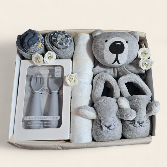kraamcadeau neutraal grijs met knuffel, besteksetje, slofjes en sokjes