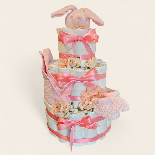 Roze luiertaart voor een meisje met 54 pamper, slofjes, spuugdoekje en een speendoekje konijn