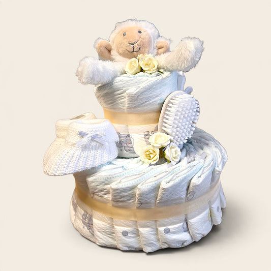 Luxe crème luiertaart met 26 luiers, Happy Horse schaap knuffeldoekje, babyborstel en kam, afgewerkt met bloemen en linten.